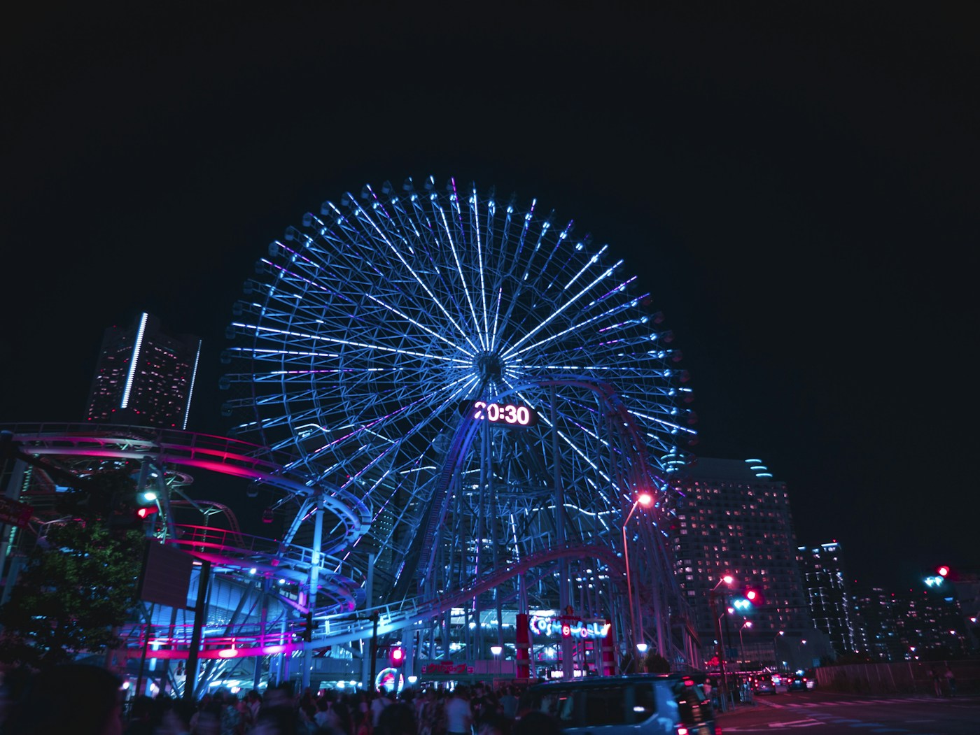 Ferris wheel and amusement park glowing at night