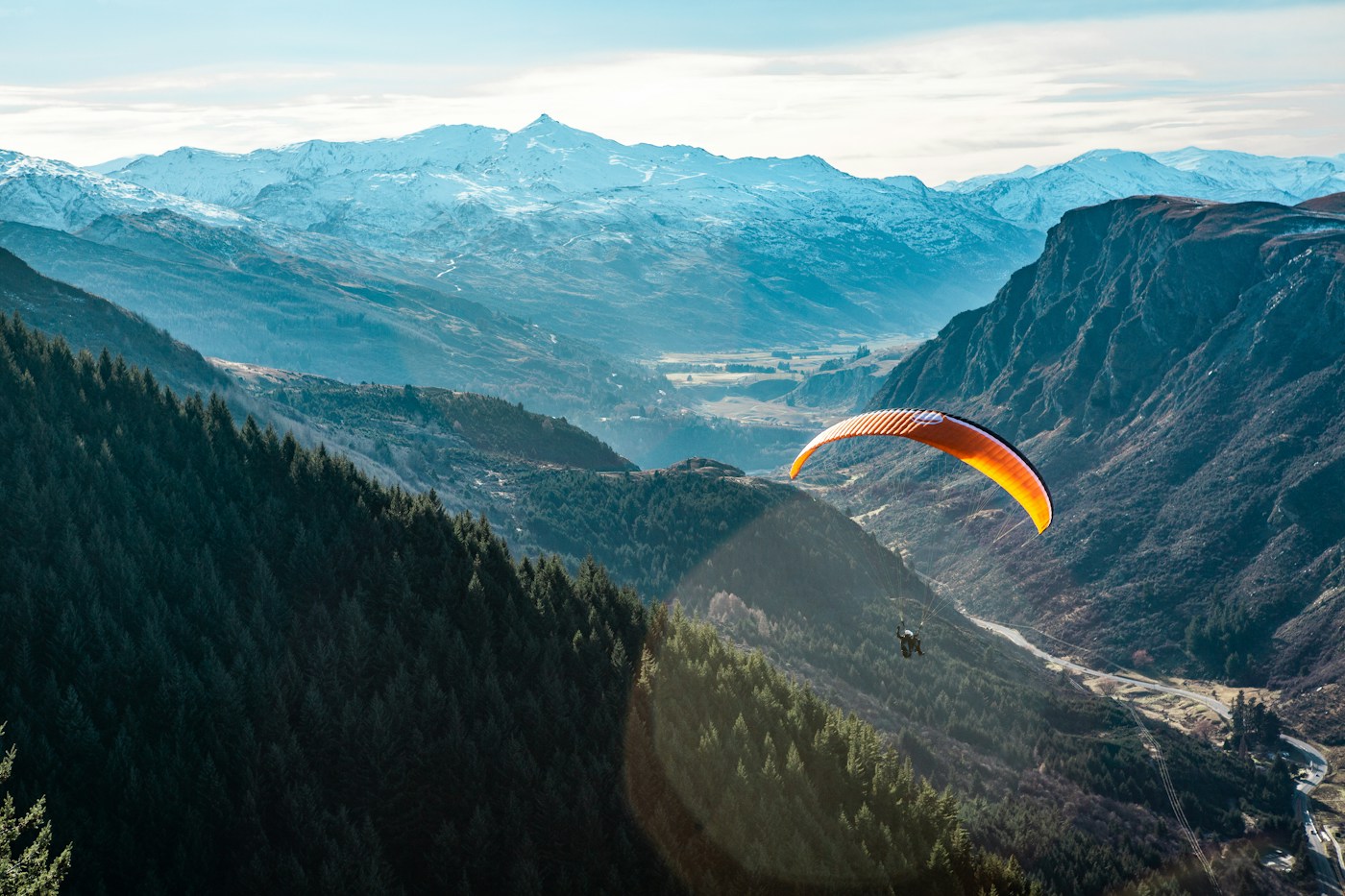 Paraglider above a dramatic mountain valley